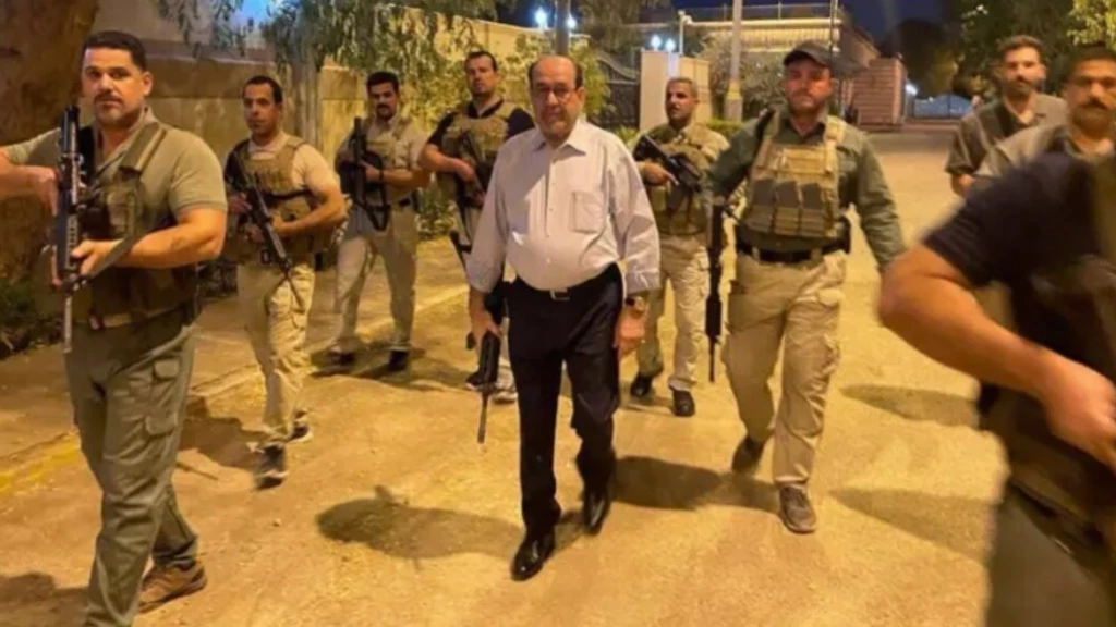 رئيس الوزراء العراقي السابق نوري المالكي وهو يحمل سلاحا ويمشي في الشارع
