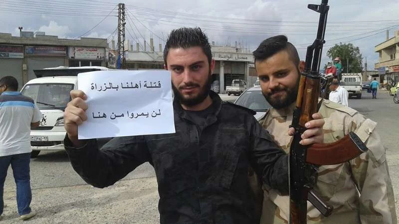 بالصور.. موالون للنظام يقطعون طريق حمص "لن تمروا من هنا"!