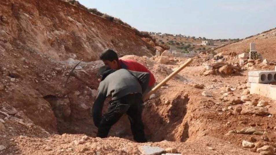 قصة مؤلمة لطفلين سوريين يعتاشان من حفر القبور بإدلب