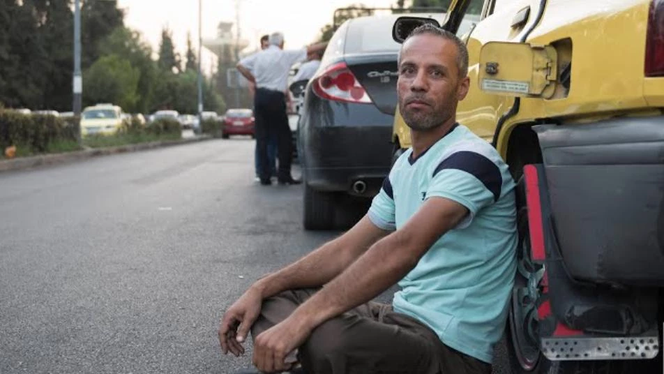 سائق أجرة سوري ينتظر دوره في طابور لتعبئة البنزين