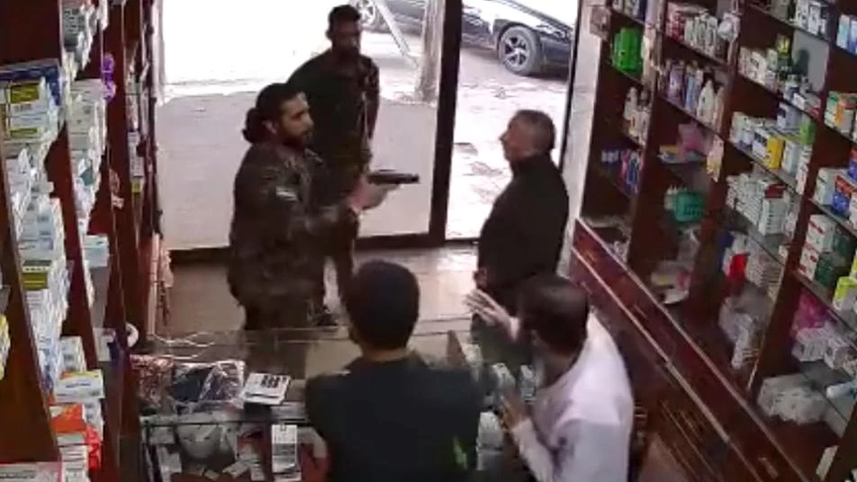 بالمسدس والبندقية.. عنصر من الجيش الوطني يتهجم على أحد الصيادلة في عفرين بحلب (فيديو)