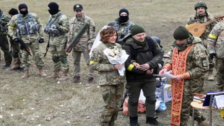 محاطون بالمقاتلين.. حفل زفاف بأرض المعركة بأوكرانيا يتحدى الغزو الروسي -فيديو